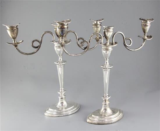 A pair of George V silver two branch, three light oval candelabra by Barker Brothers, weighted.